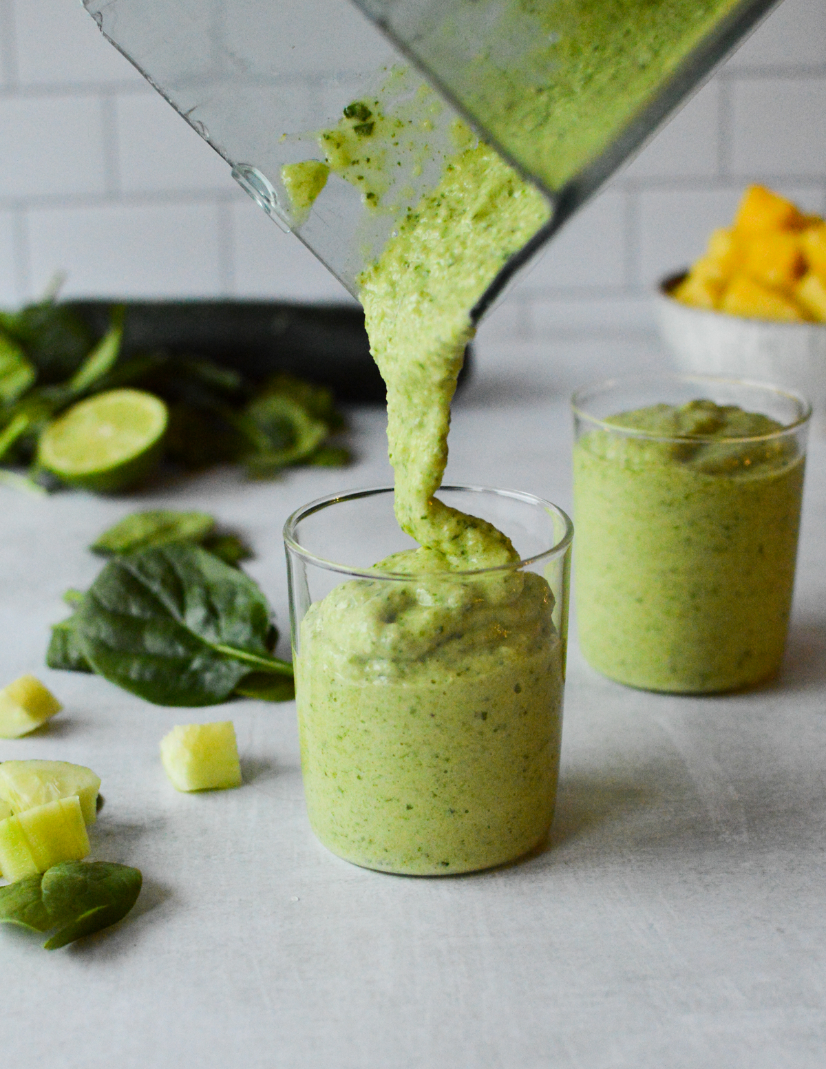 pouring a spinach cucumber smoothie into a glass.