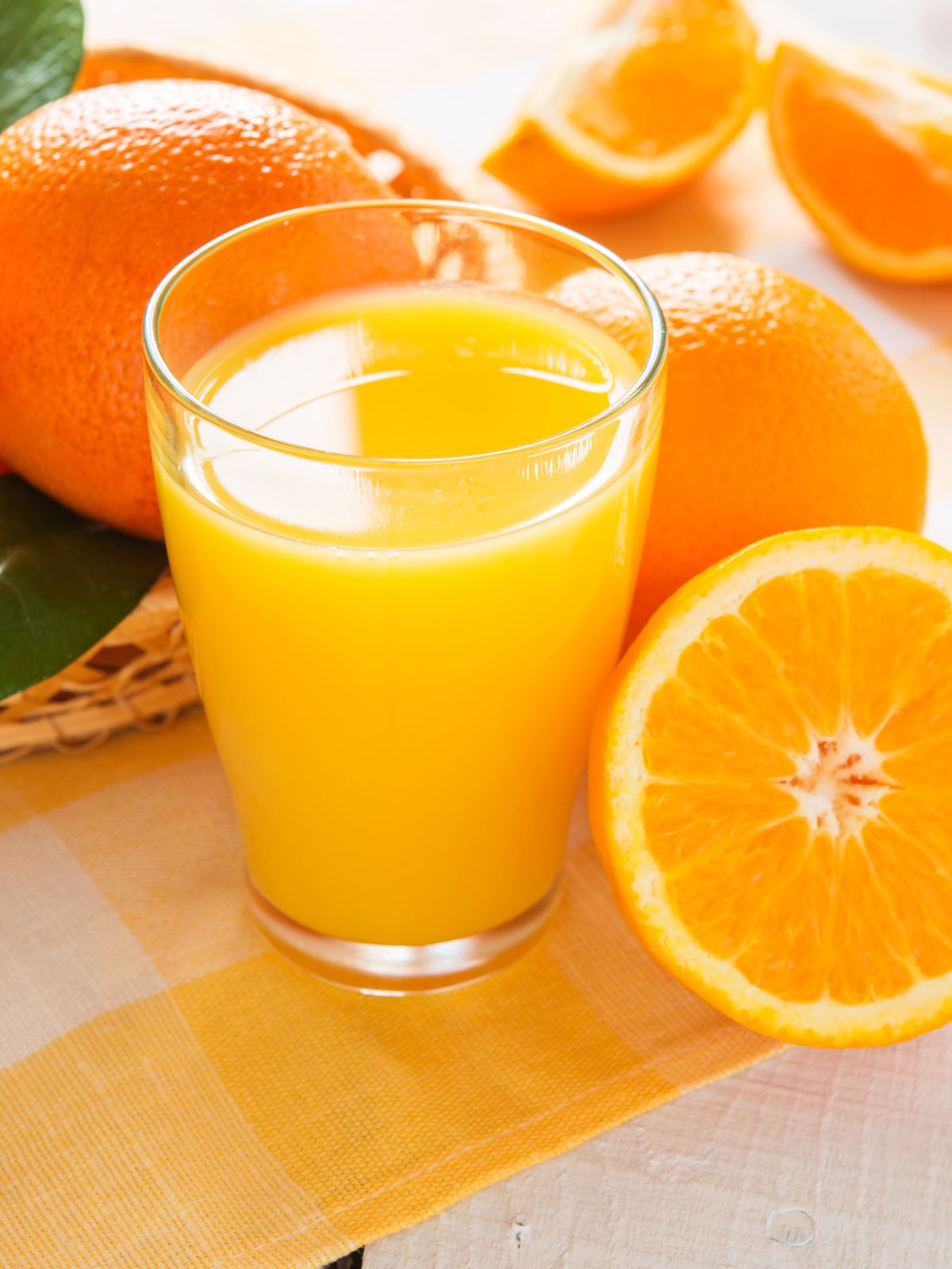 a glass of orange juice with oranges.