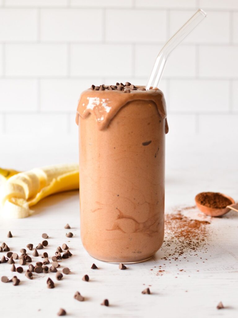 chocolate banana smoothie on table with chocolate chips.