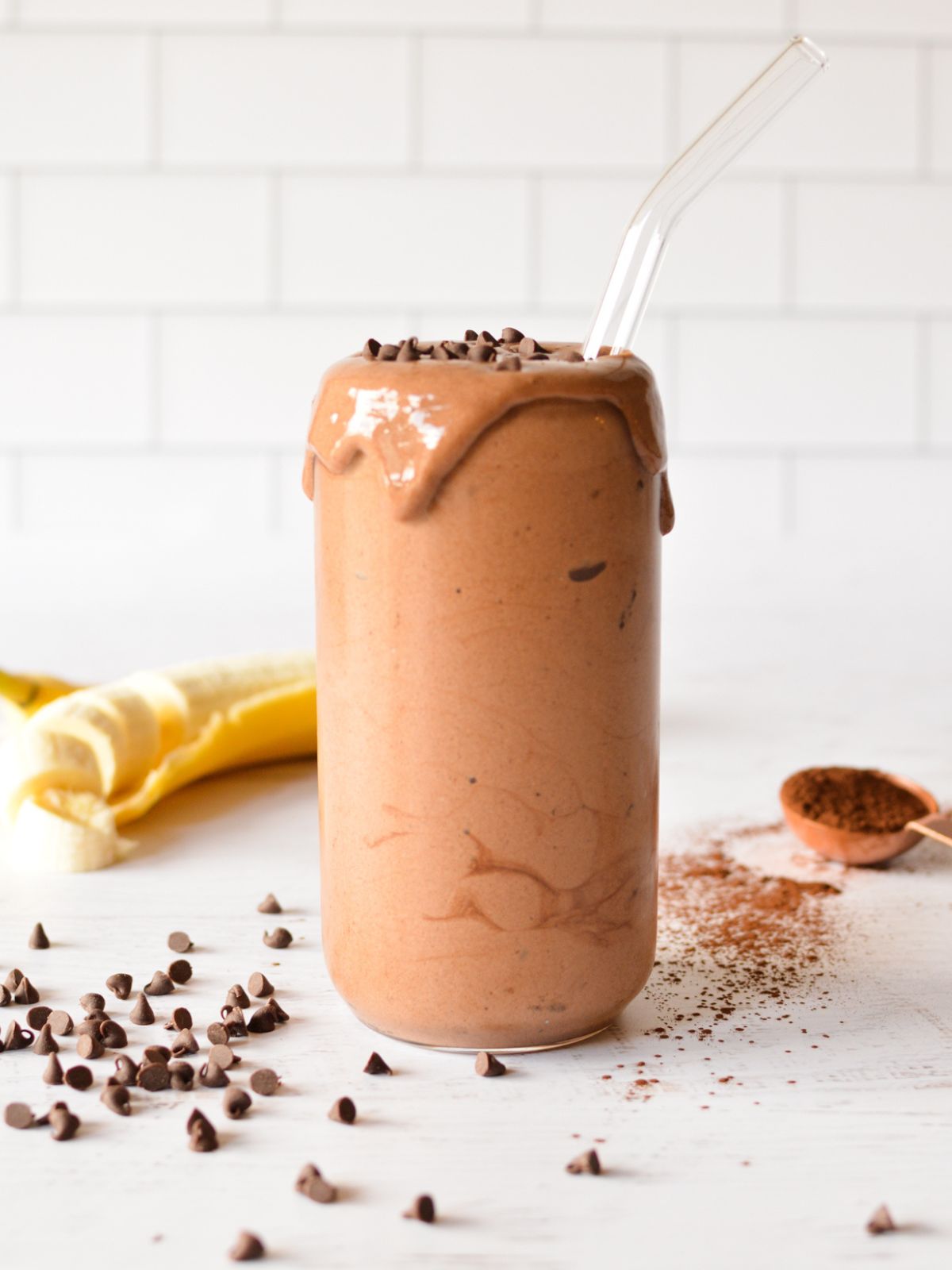 chocolate banana smoothie on table with chocolate chips.