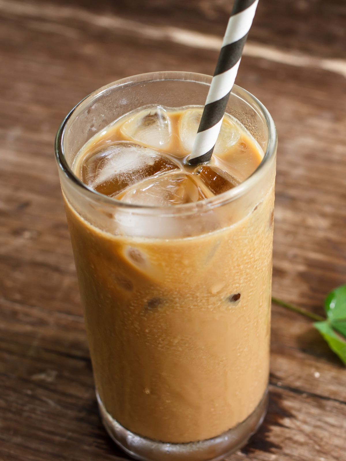 a cup of iced coffee with a striped straw.