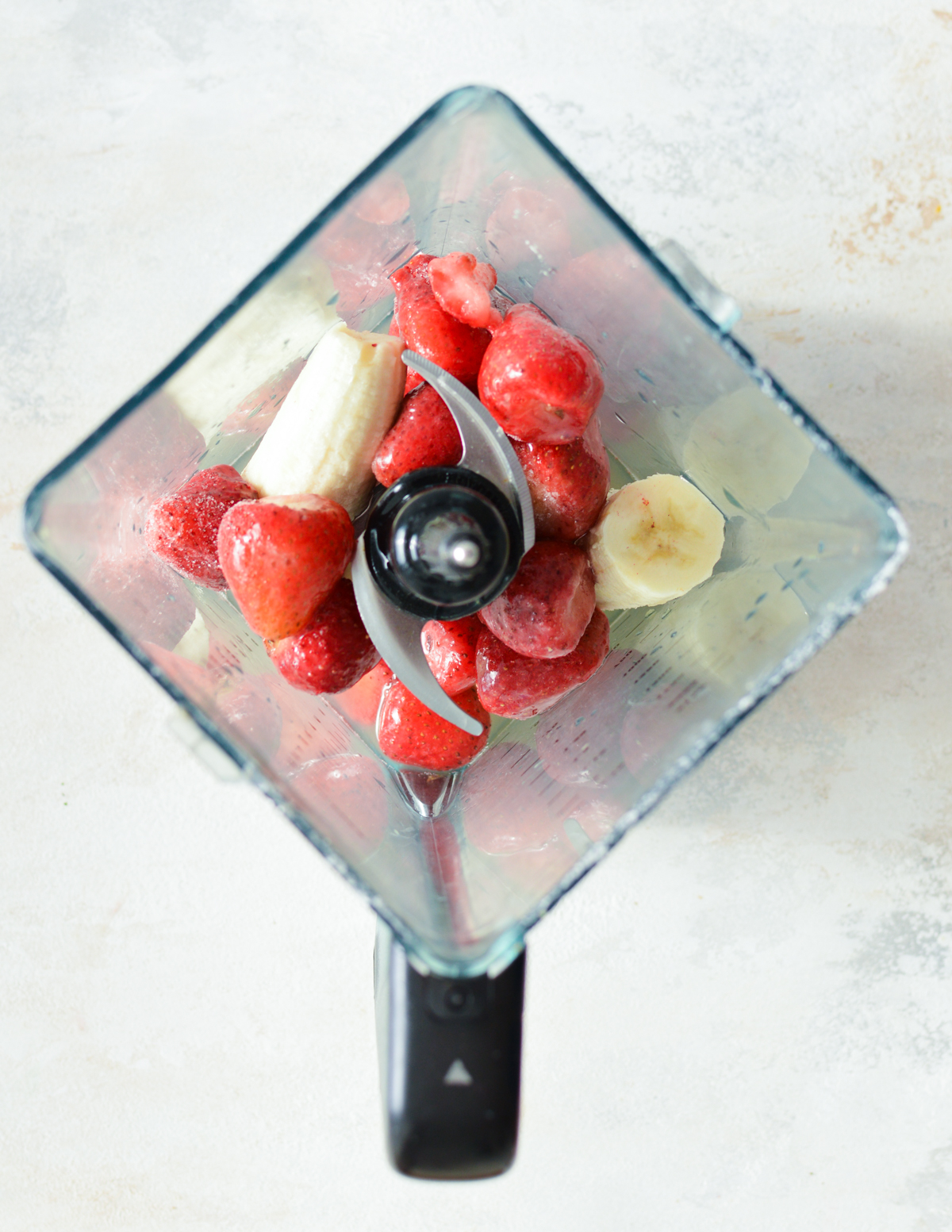 strawberries, banana, and cucumber in a blender.