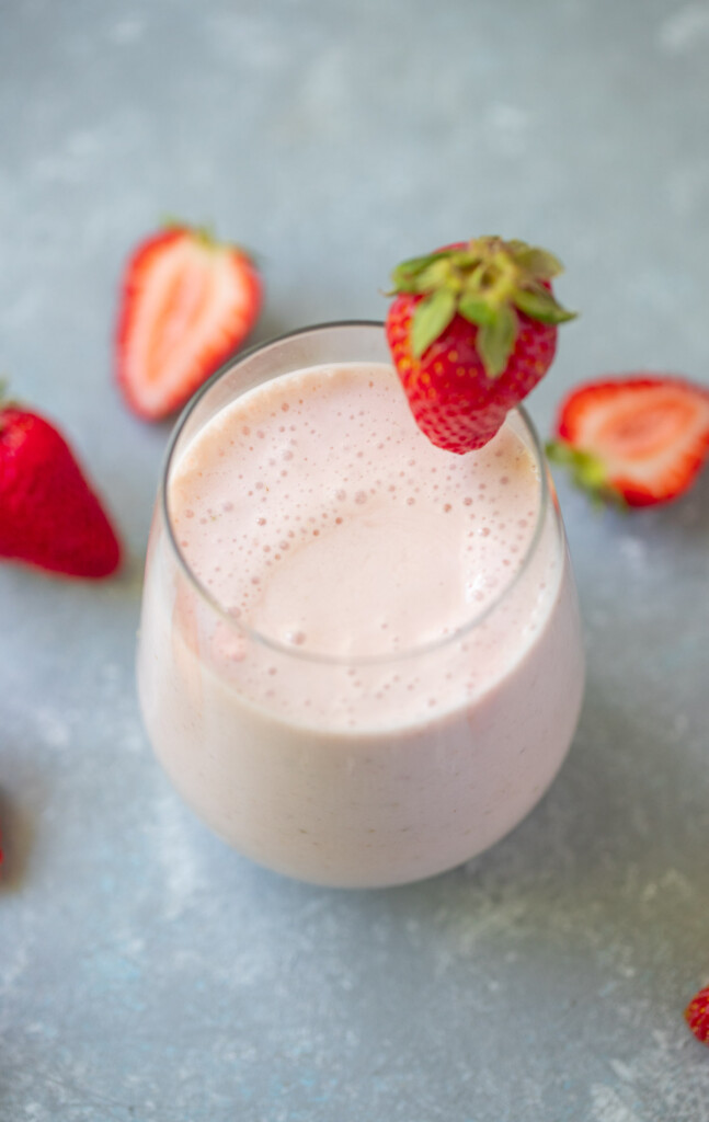 strawberry smoothie with a strawberry on the side.