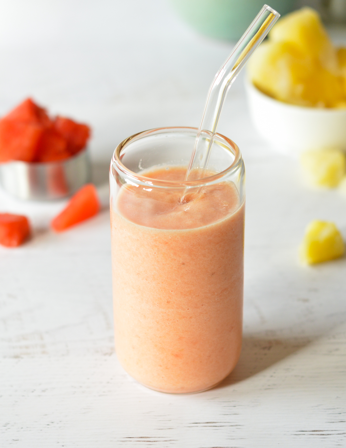 pineapple watermelon smoothie with a straw.