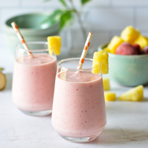 strawberry smoothies with straws and pineapple