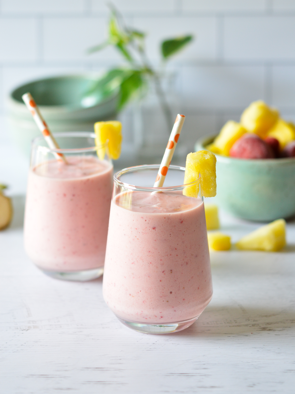 strawberry smoothies with straws and pineapple