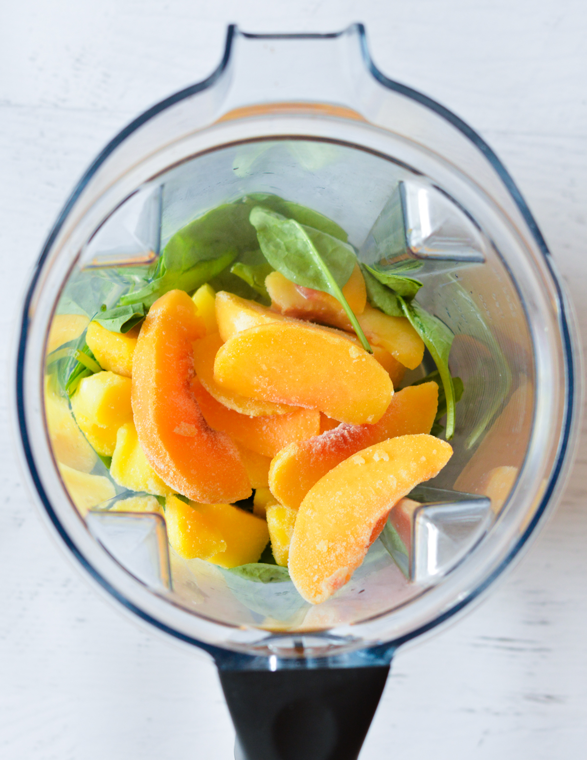 spinach, peaches, and mango in a blender.