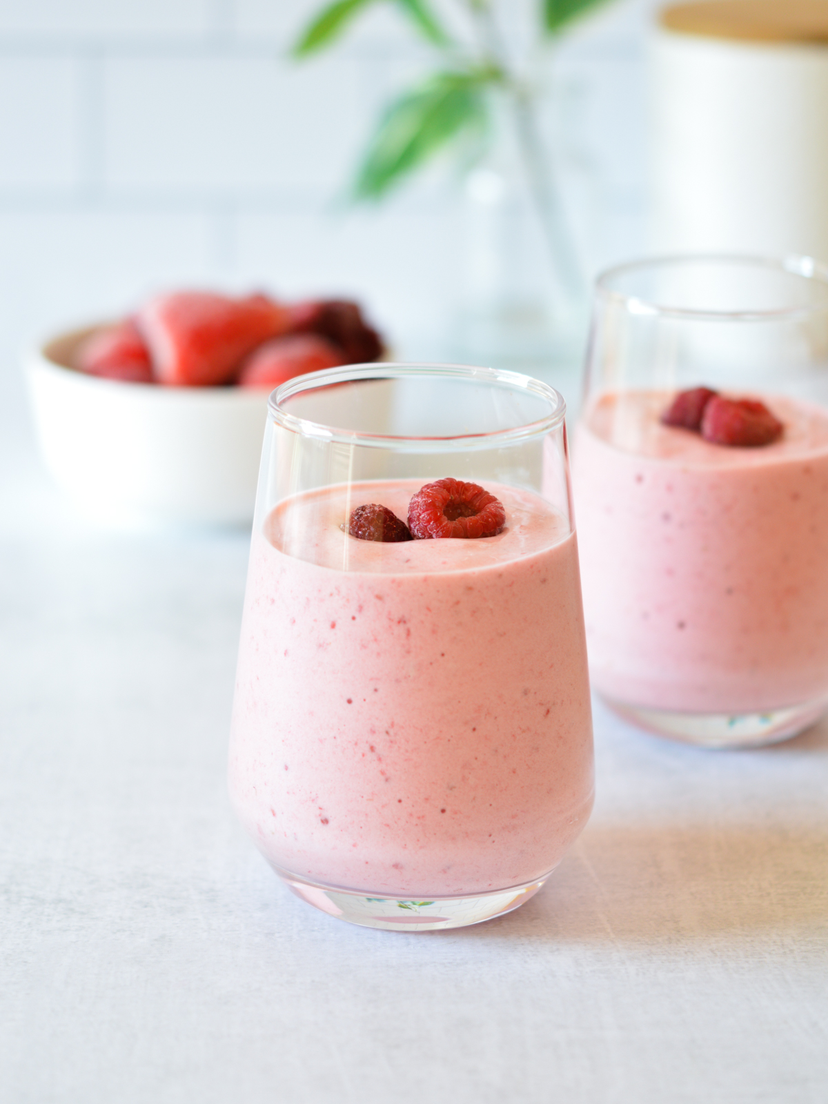 berry smoothies with raspberries on top.