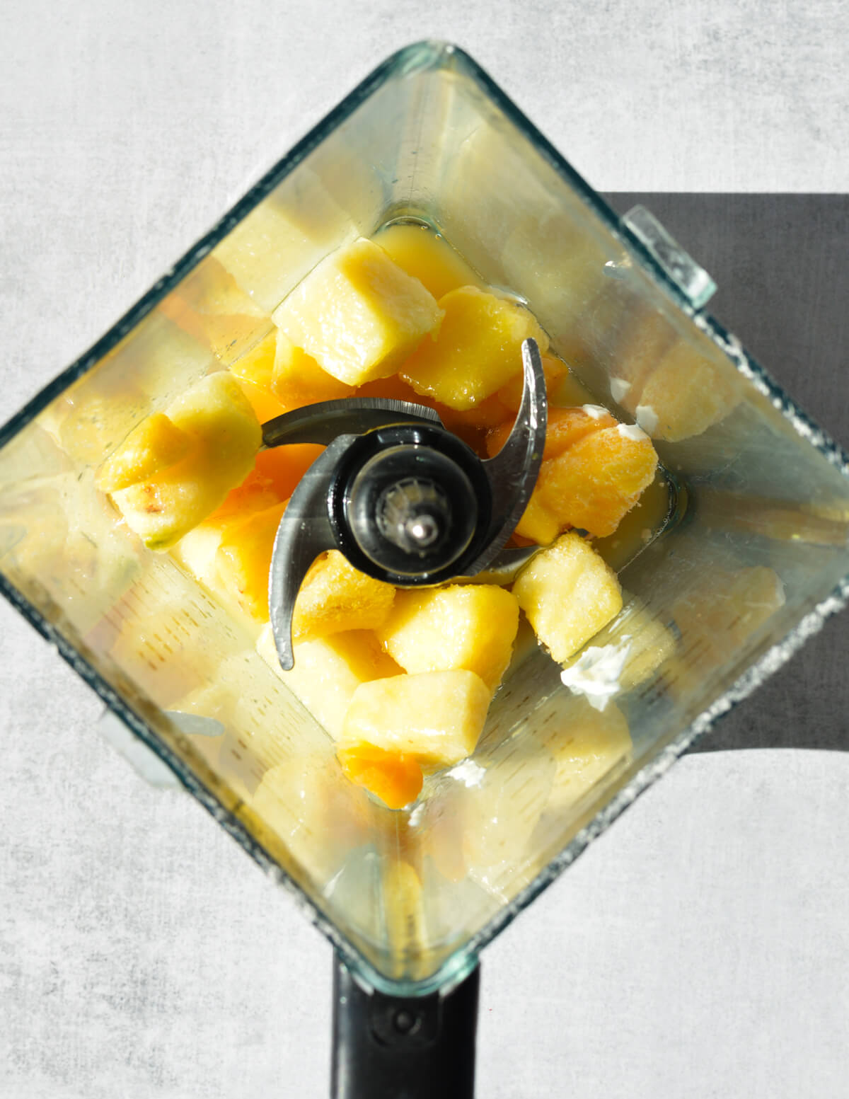 frozen pineapple and frozen mango in a blender.